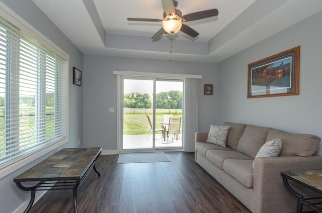 324 Bluebird Dr NW, Isanti, MN 55040 - living room featuring a tray ceiling, healthy amount of natural light, ceiling fan, and dark wood-style flooring