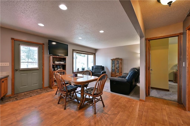 dining space featuring a textured ceiling, light wood-style flooring, and recessed lighting