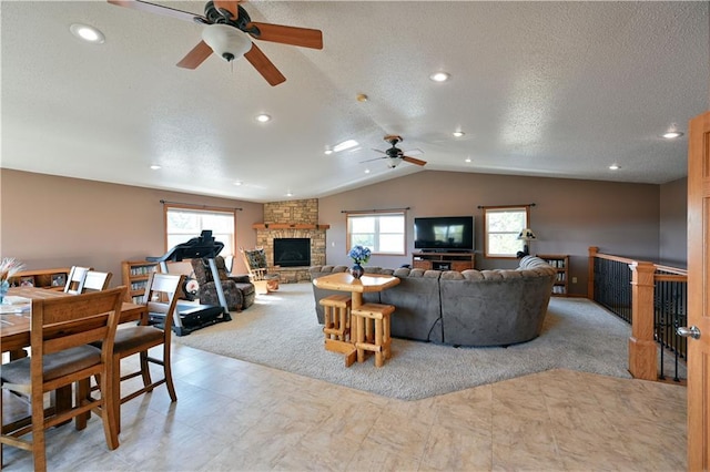 living room with lofted ceiling, light carpet, a stone fireplace, and a textured ceiling