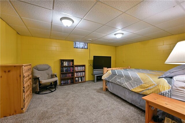 carpeted bedroom with concrete block wall