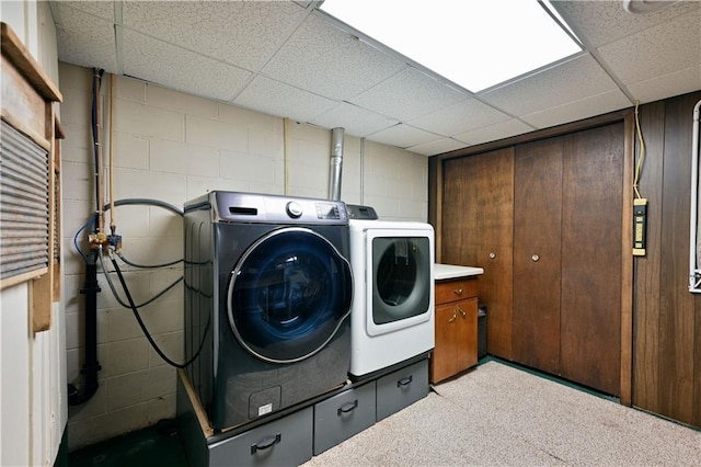 laundry area with concrete block wall, laundry area, and washer and clothes dryer