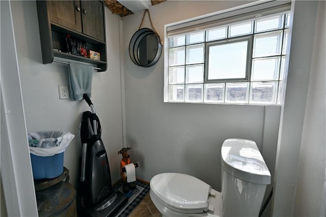 bathroom featuring a wealth of natural light, tile patterned flooring, and toilet