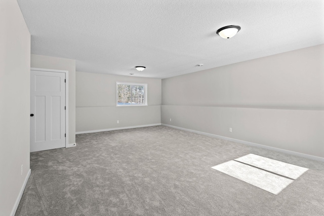 empty room featuring carpet floors, baseboards, and a textured ceiling