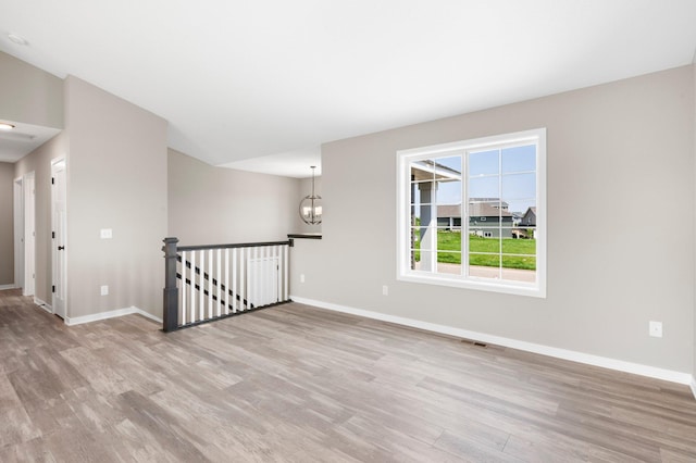 1003 Misty Meadow Blvd, Buffalo, MN 55313 - unfurnished room with light wood-style floors, baseboards, and a chandelier