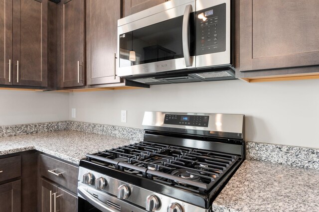 1003 Misty Meadow Blvd, Buffalo, MN 55313 - kitchen with appliances with stainless steel finishes, dark brown cabinetry, and light stone counters