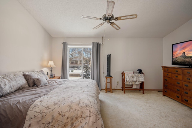 bedroom featuring light colored carpet, ceiling fan, a textured ceiling, and baseboards