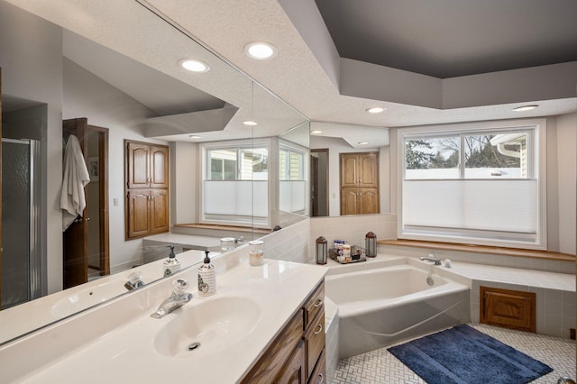 bathroom with a wealth of natural light, tile patterned floors, a bath, and vanity