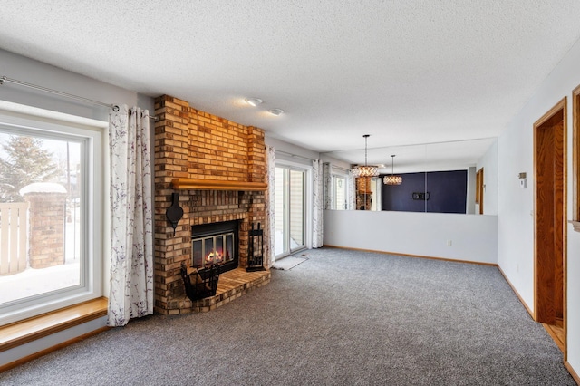 unfurnished living room with a textured ceiling, a brick fireplace, carpet flooring, and baseboards