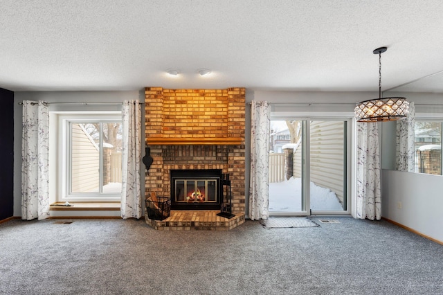 unfurnished living room with carpet, a wealth of natural light, and a brick fireplace