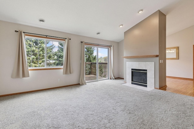 15374 Flower Way, Apple Valley, MN 55124 - unfurnished living room featuring carpet floors, a tile fireplace, vaulted ceiling, and baseboards