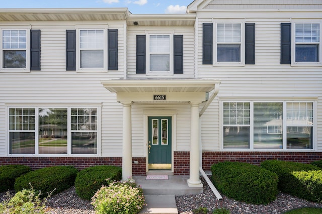 view of exterior entry featuring brick siding