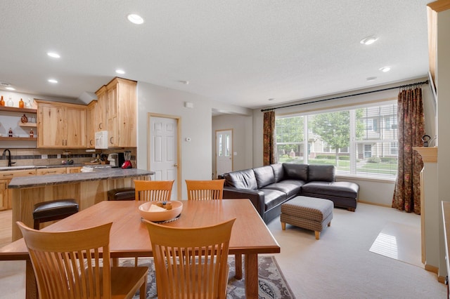 dining space featuring recessed lighting, light colored carpet, and a textured ceiling