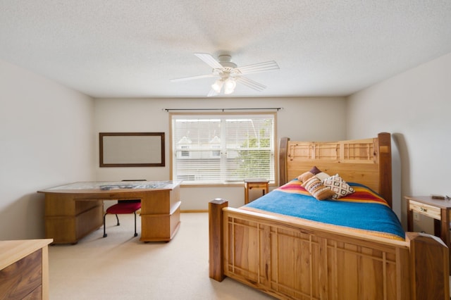 bedroom with ceiling fan, a textured ceiling, and light colored carpet