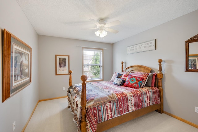 bedroom with a ceiling fan, a textured ceiling, baseboards, and carpet flooring