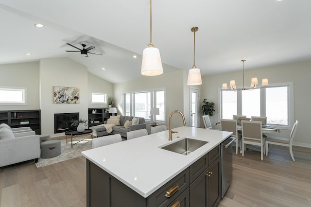 kitchen with dishwasher, light countertops, a sink, and light wood-style floors