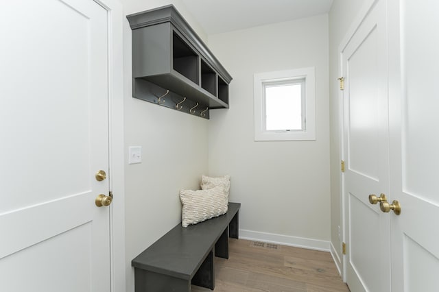 mudroom with light wood-type flooring, visible vents, and baseboards