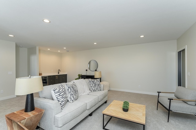 living area with baseboards, light carpet, and recessed lighting