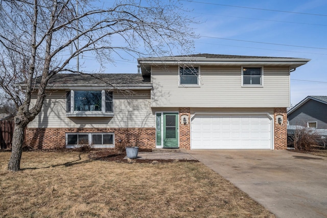 tri-level home with concrete driveway, an attached garage, brick siding, and a front lawn