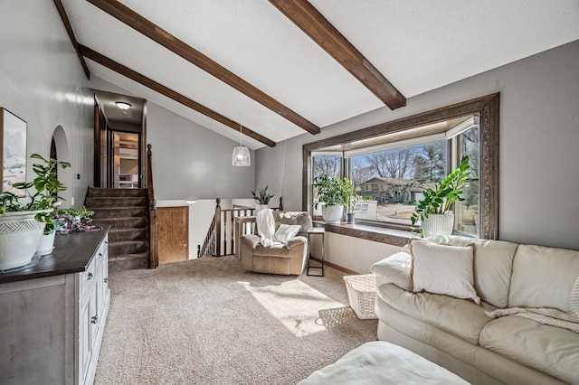 living room featuring stairway, light colored carpet, a textured ceiling, and lofted ceiling with beams