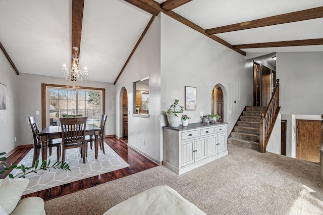 carpeted dining space with baseboards, an inviting chandelier, vaulted ceiling with beams, arched walkways, and stairs