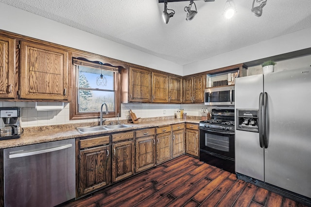 kitchen with a sink, stainless steel appliances, dark wood-type flooring, and decorative backsplash