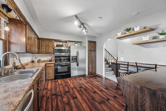 kitchen with dark wood-type flooring, a sink, open shelves, tasteful backsplash, and stainless steel appliances