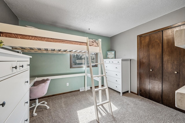 bedroom featuring baseboards, visible vents, a textured ceiling, and carpet