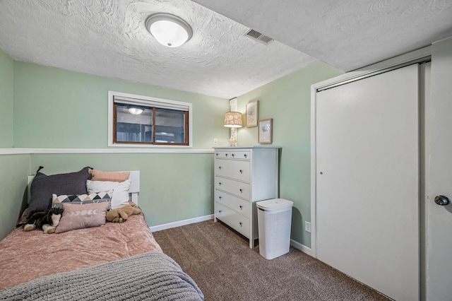 carpeted bedroom with visible vents, baseboards, a textured ceiling, and a closet