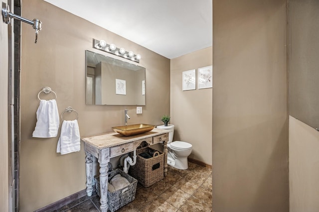 bathroom featuring vanity, toilet, and baseboards