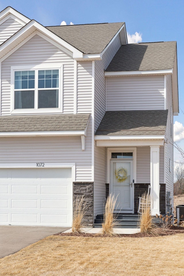 view of front of home with a garage, roof with shingles, central AC, and driveway