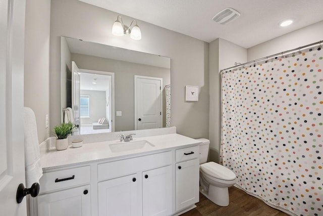 full bath featuring vanity, wood finished floors, visible vents, curtained shower, and toilet