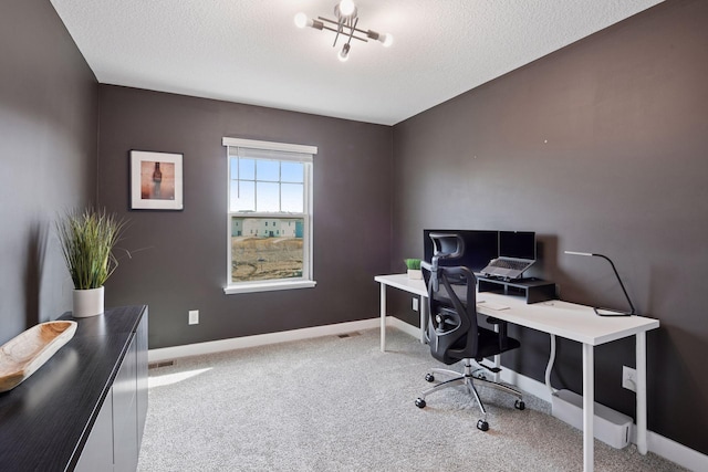 carpeted home office featuring baseboards and a textured ceiling