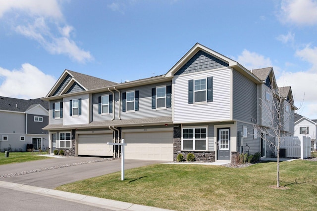 8730 Parkington Ave NE, Otsego, MN 55330 - view of property with a front lawn, driveway, stone siding, and a garage