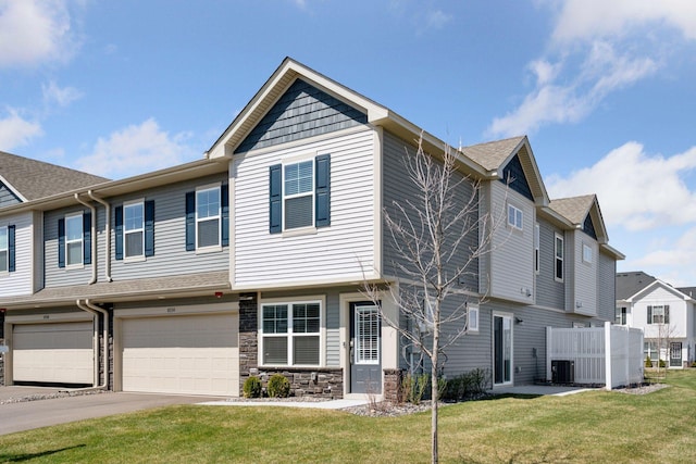 8730 Parkington Ave NE, Otsego, MN 55330 - townhome / multi-family property featuring central air condition unit, driveway, stone siding, a garage, and a front yard