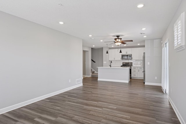 8730 Parkington Ave NE, Otsego, MN 55330 - unfurnished living room with a sink, baseboards, stairs, ceiling fan, and dark wood-type flooring