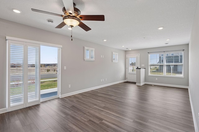 8730 Parkington Ave NE, Otsego, MN 55330 - unfurnished living room featuring a ceiling fan, baseboards, and dark wood-type flooring