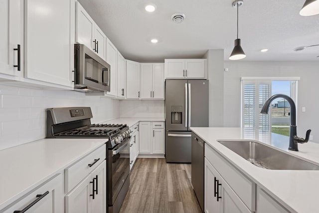 8730 Parkington Ave NE, Otsego, MN 55330 - kitchen with white cabinets, light wood finished floors, stainless steel appliances, visible vents, and a sink