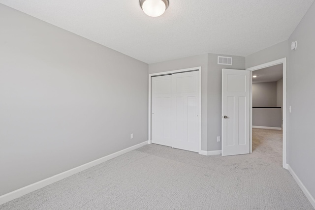 8730 Parkington Ave NE, Otsego, MN 55330 - unfurnished bedroom with carpet flooring, a textured ceiling, baseboards, visible vents, and a closet