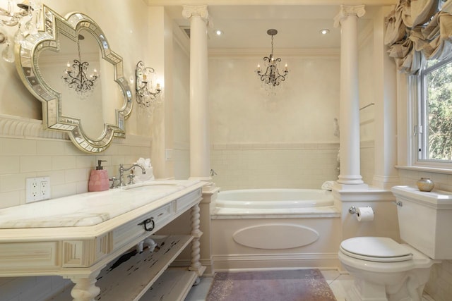 2427 Lake Of The Isles Pkwy, Minneapolis, MN 55405 - bathroom with decorative columns, toilet, a chandelier, a garden tub, and vanity