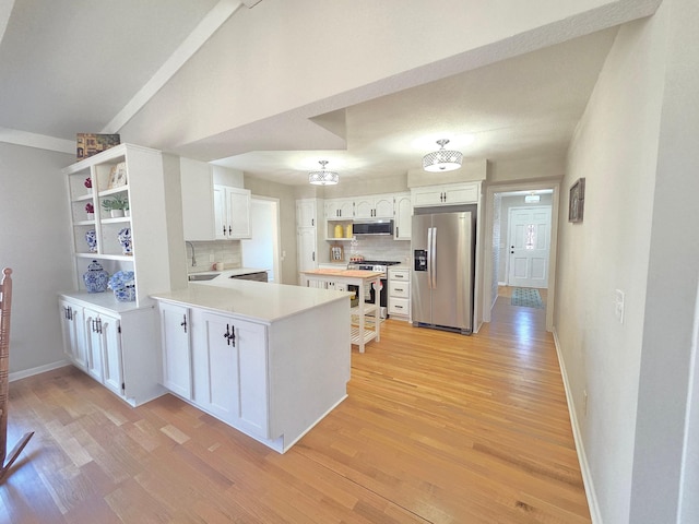 kitchen featuring open shelves, light wood-style floors, a peninsula, and stainless steel appliances