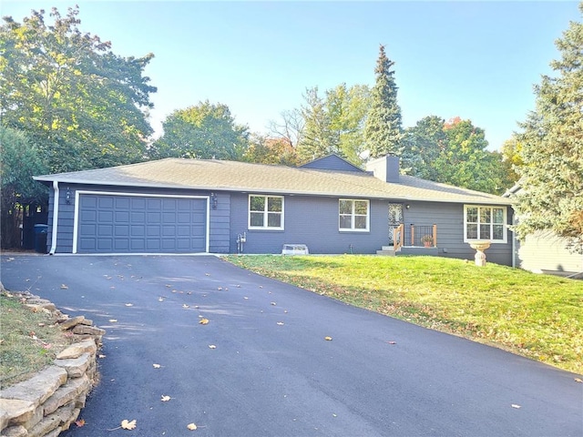 ranch-style house with a chimney, aphalt driveway, a front lawn, and an attached garage