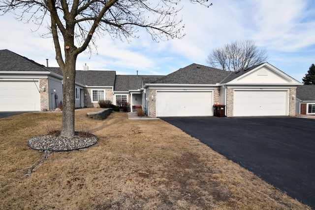 ranch-style home featuring a garage, brick siding, a shingled roof, driveway, and a chimney