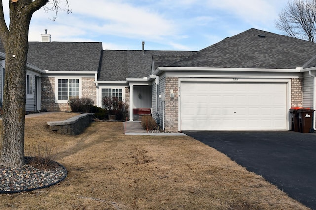 single story home featuring a garage, aphalt driveway, a chimney, and a shingled roof