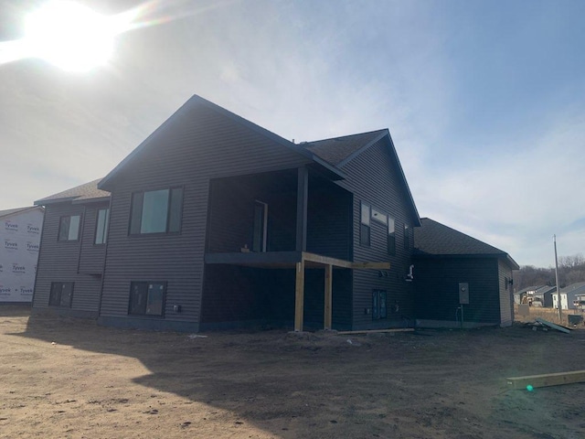 back of property with roof with shingles