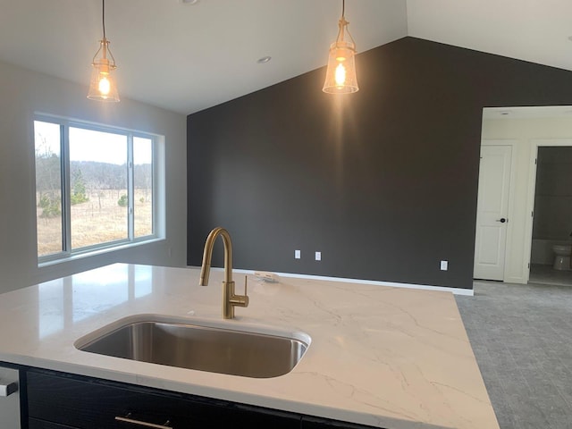 kitchen with lofted ceiling, decorative light fixtures, a sink, and light stone countertops