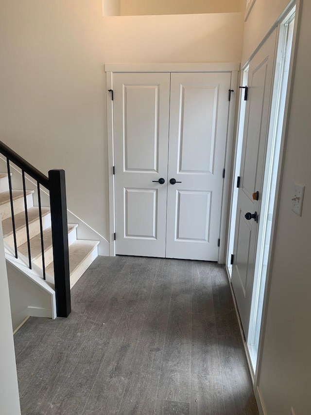 hallway with baseboards, stairway, and dark wood finished floors