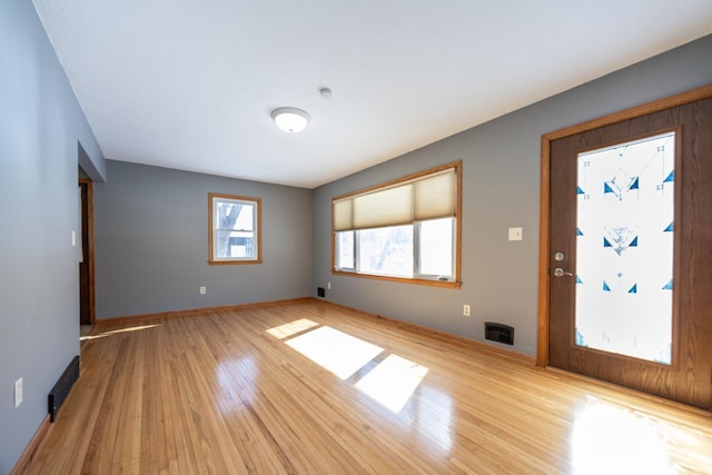 interior space featuring light wood-type flooring, baseboards, and heating unit