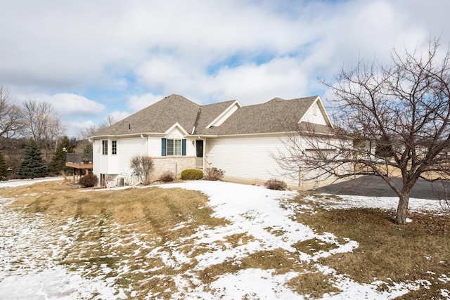 snow covered property featuring a shingled roof