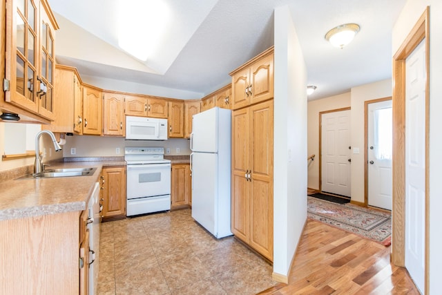 kitchen with light brown cabinets, glass insert cabinets, light countertops, white appliances, and a sink