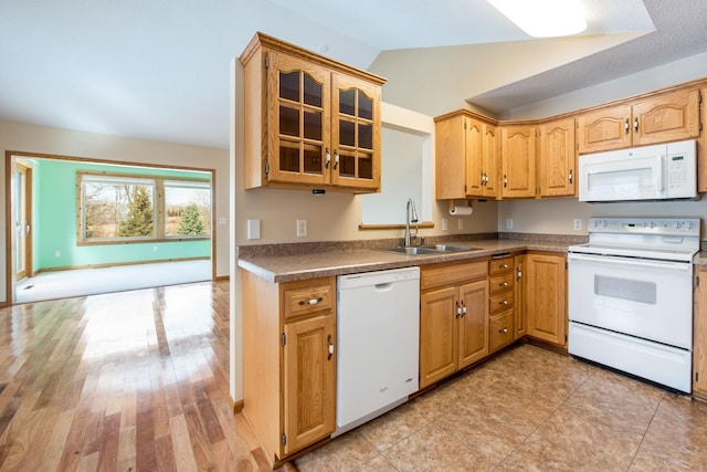 kitchen featuring a sink, white appliances, light wood-style floors, glass insert cabinets, and lofted ceiling